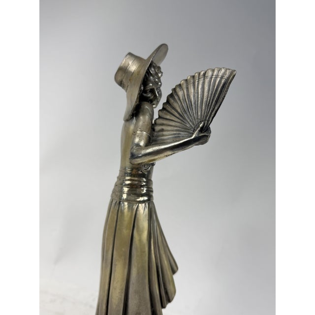 Beautiful metal statue depicting a well-dressed woman with a hat and fan. Excellent decorative objects.