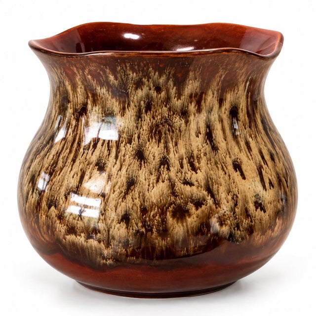 A beautifully glazed example of American art pottery, this vintage Haeger planter showcases a rich brown drip glaze with...