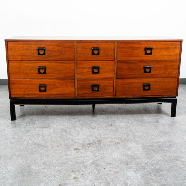 Handsome 9 drawer credenza dresser in walnut. Sculpted metal rounded handled within each drawer. Signed within the top...