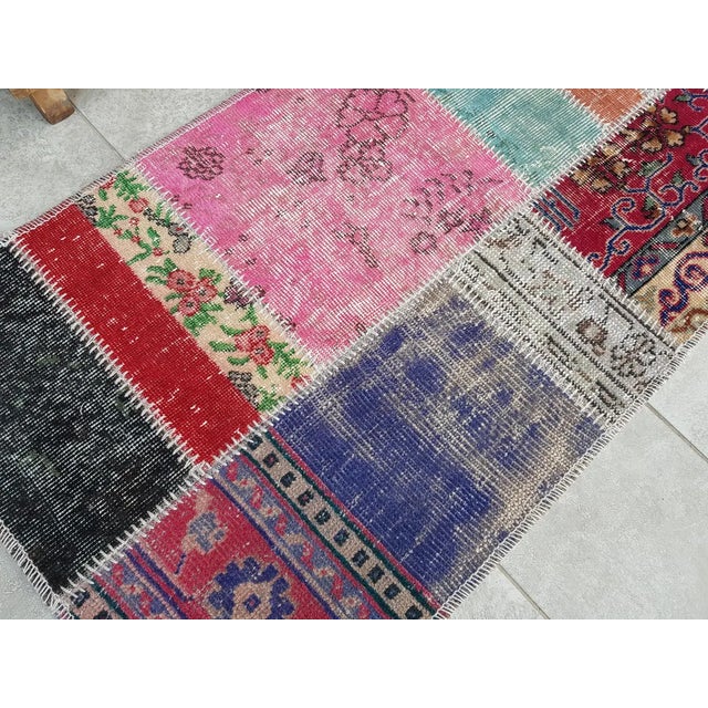 This is a vintage Turkish Oushak rug from the Mid 20th Century. The piece was hand-knotted.