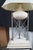 Late 20th Century Neoclassical Directoire Style Table Lamp. Features a round travertine urn shaped center supported by a...