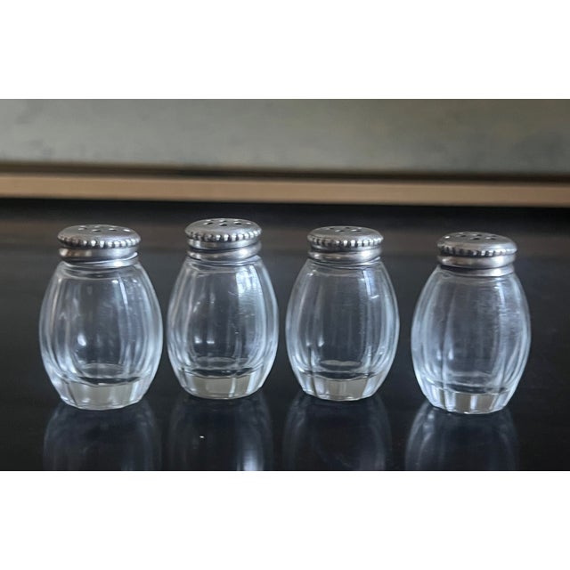Set of four small salt and pepper shakers made by Orefevre Christofle in France in the 1960's. Each shaker has a crystal...