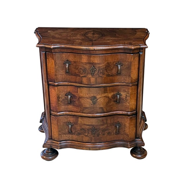 the serpentine top with well-figured mirror-veneered central reserve within a banded border; above a conforming similarly-...