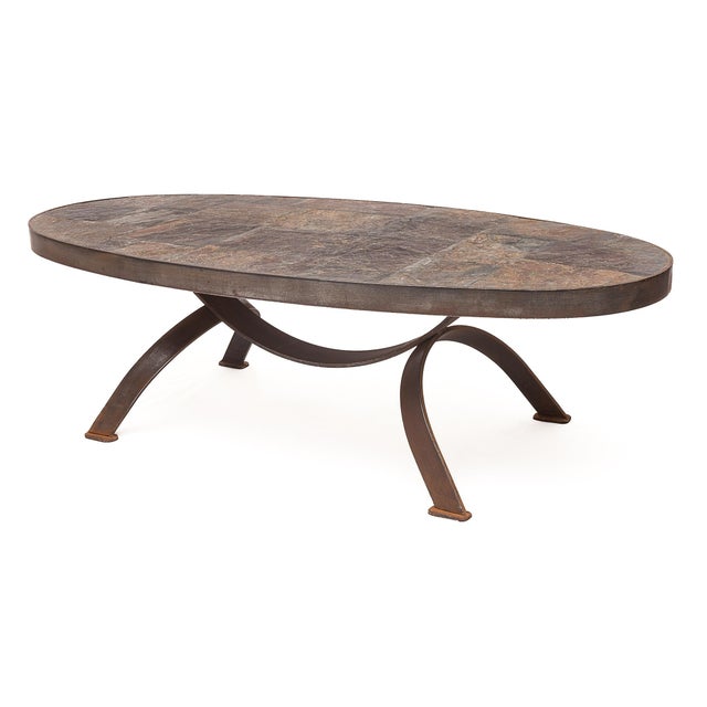 Set of two oval Brutalist coffee tables, in the style of Jean Jaffeux. Wrought iron base. Raw slate top. Iron rim. Circa 1950