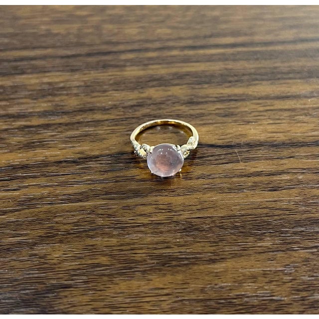 Elegant 14K Gold Ring with Rose Quartz Center Stone. This exquisite ring features a smooth, round-shaped rose quartz set...