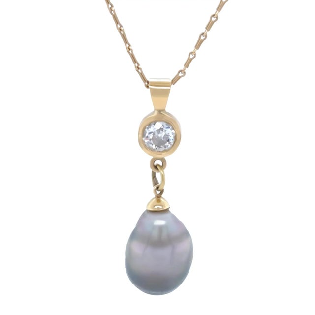 An elegant 18ct yellow gold lady’s drop pendant featuring a striking baroque black cultured pearl measuring approximately...