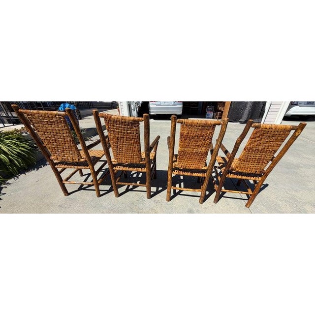 Set of four old hickory arm chairs with original rattan seating. Signed Shellby ville,Indiana on every chair.We have a...
