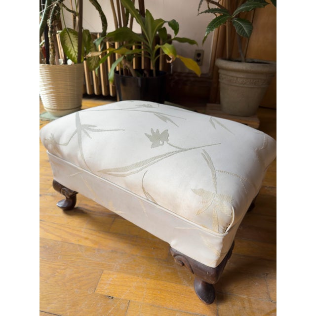 This mid-20th-century footstool references classic Chippendale and Queen Anne design with cabriole legs and club foot in a...