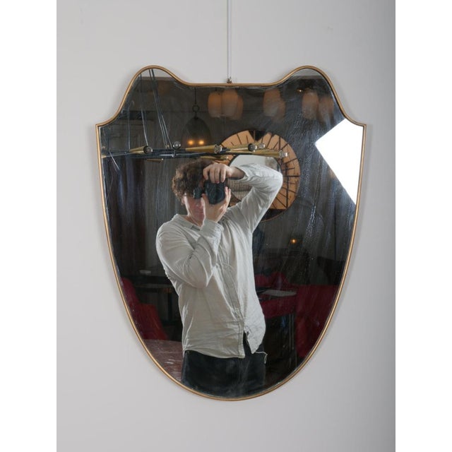 Good quality brass frame wall mirror in shape of shield. Italy c1950 Mirror plate with minimal age. Brass has nice...