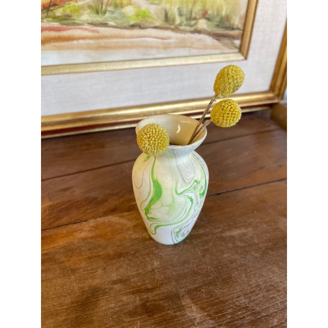 Small vintage studio pottery bud vase featuring a softly flared rim and rounded body with a narrow neck. The surface is...