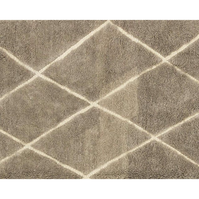 Luxurious hand-knotted and handwoven rug with a diamond pattern in a sophisticated Misty Taupe and Ivory palette, creating...