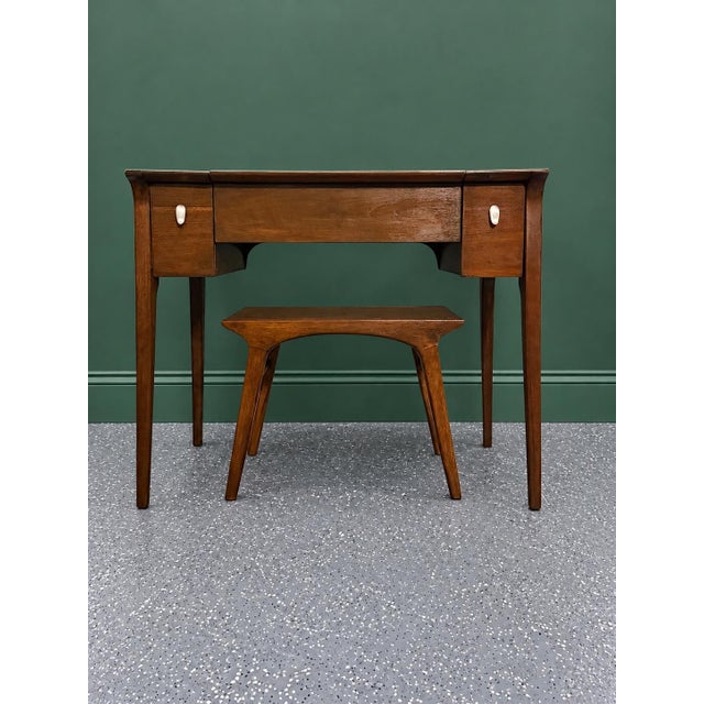 Mid-century Drexel Profile walnut vanity and matching stool by John Van Koert. It showcases the collection's signature...