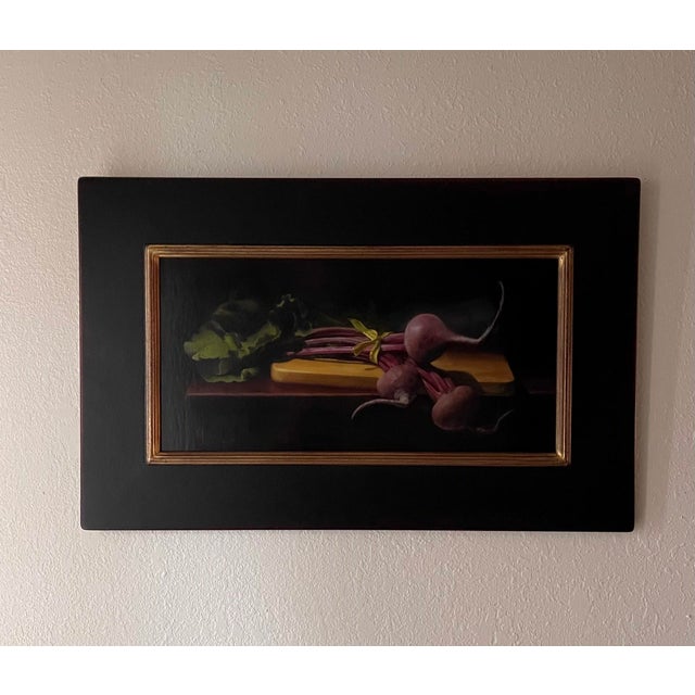 This oil on panel artwork depicts a vibrant arrangement of locally grown beets, their rich colors contrasted against a...