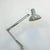 Grey architect's desk lamp with articulated double arm, weighted springs, and clamp-on base. Steel shade with perforated...