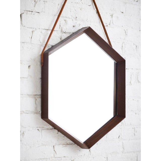 Mid-century Italian hexagonal wall mirror in walnut frame. Features original leather strap. Sourced in Italy.