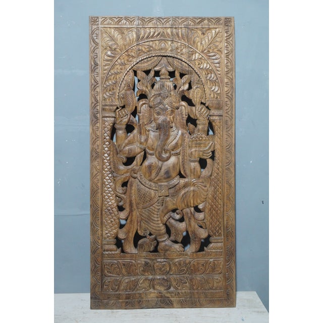 Celebrate the beauty of traditional Indian craftsmanship with this antique hand-carved wooden wall panel featuring a...