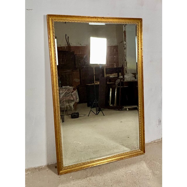 Elegant large Spanish wall mirror featuring a finely crafted giltwood frame with carved decorative mouldings and a warm...