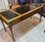 This Vintage Brandt Regency Revival Neoclassical Writing Desk with Black Tooled Leather Inset Top has a classically...