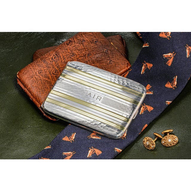 A striking expression of Art Deco elegance, this vintage sterling silver cigarette case is elevated by bold 14K gold...