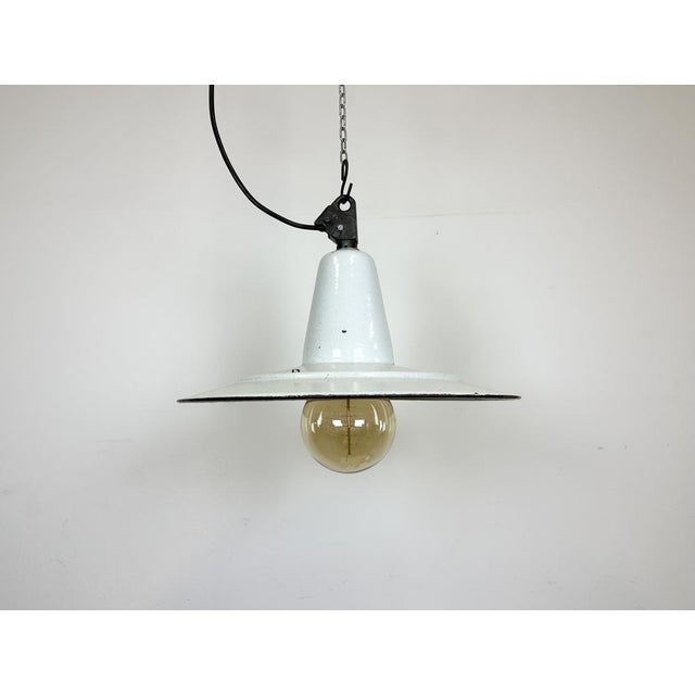 Industrial dark white (light grey) enamel pendant light made in Poland during the 1960s. White enamel inside the shade....