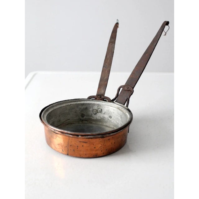 Pair of antique copper sauté pans crafted from heavy gauge copper with traditional hand-applied tin linings. Each pan...