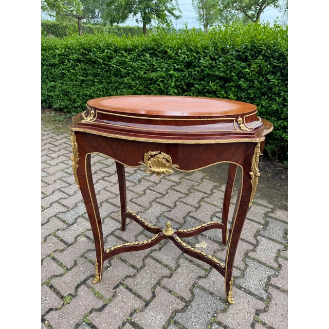 A refined pair of 1920 French Louis XVI-style side tables, beautifully crafted from mahogany and decorated with elegant...