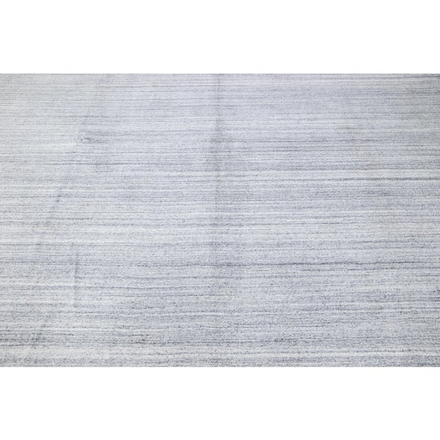 Beautiful modern hand-Loom wool rug with an ivory field. This piece has gray accents in a gorgeous all-over geometric...