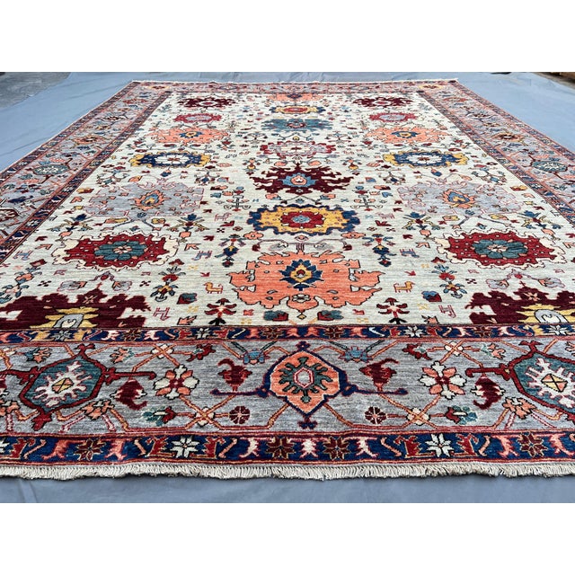 This hand knotted Afghan Sultanabad rug features a classic floral design with a warm ivory field and rich accents of...