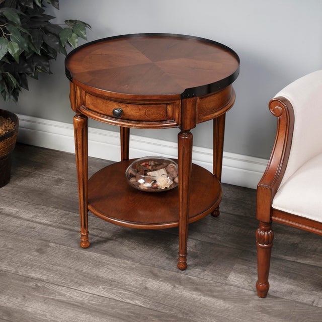 Adorned with four-way matched cherry veneers, the top of this stately accent table boasts an antique brass finished...