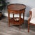 Adorned with four-way matched cherry veneers, the top of this stately accent table boasts an antique brass finished...