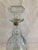 This vintage cut glass decanter showcases classic starburst detailing and a faceted stopper, offering timeless appeal and...