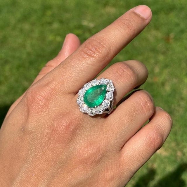 This luxurious cocktail ring featuring a 5.03 carats, pear cut emerald set in 18K white gold. Each measuring approximately...