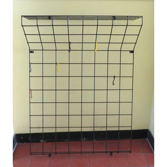 A classic from the 1950s/60s, a String wall-mounted coat rack covered in black plastic with six colored hooks: two black,...
