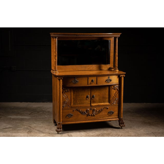 Substantial oak sideboard with attached mirror, built in the Empire Revival tradition and executed with pronounced...