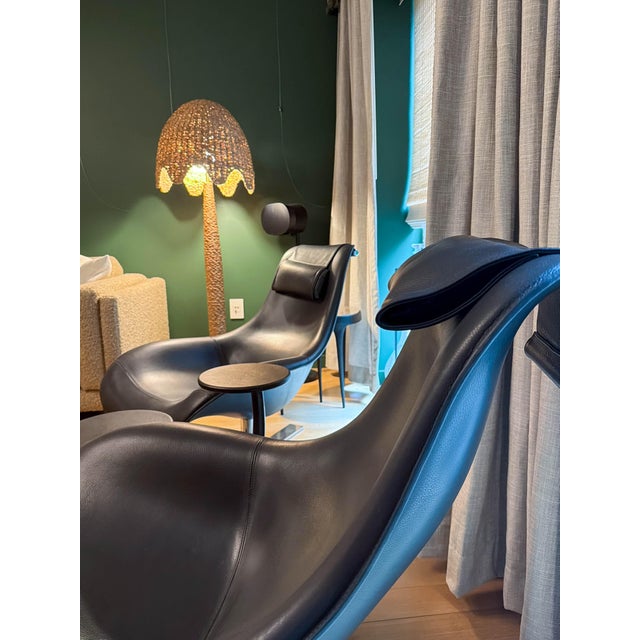 Designed by Antonio Citterio for B&B Italia, this is a matched pair of "Mart" lounge chairs upholstered in black leather...