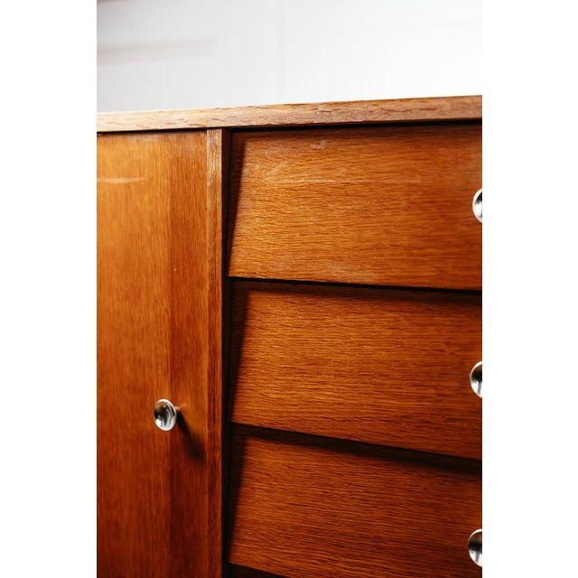 Vintage chest of drawers on tapered legs, offering storage space with a shelf behind a door and four drawers. This chest...