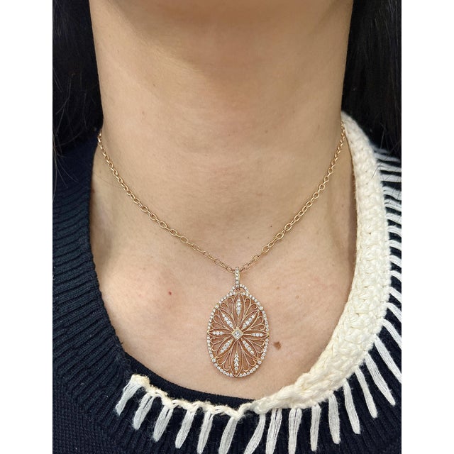 This exquisite pendant necklace features a delicate oval design adorned with 96 round white diamonds, totaling 1.38...