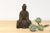A captivating antique rusted metal Buddha figure. The cast seated Buddha rests on a rectangular base adorned with two...