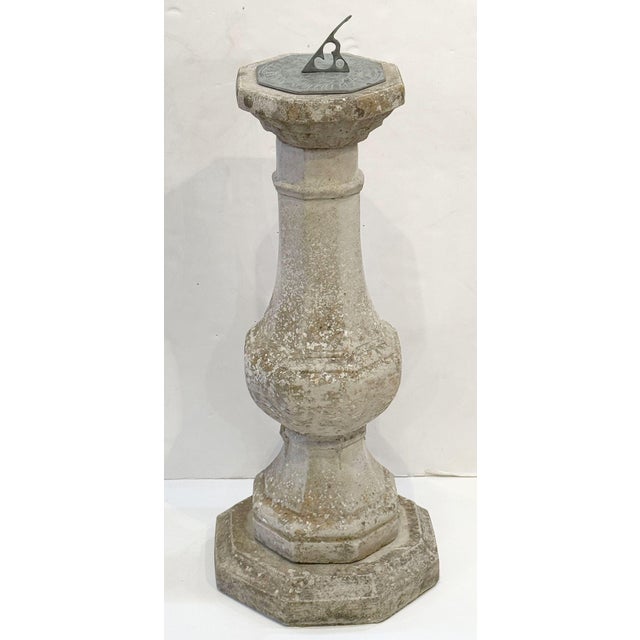 A large English sundial of composition or garden stone - featuring a bronze sundial inscribed with a sun, numerals,...