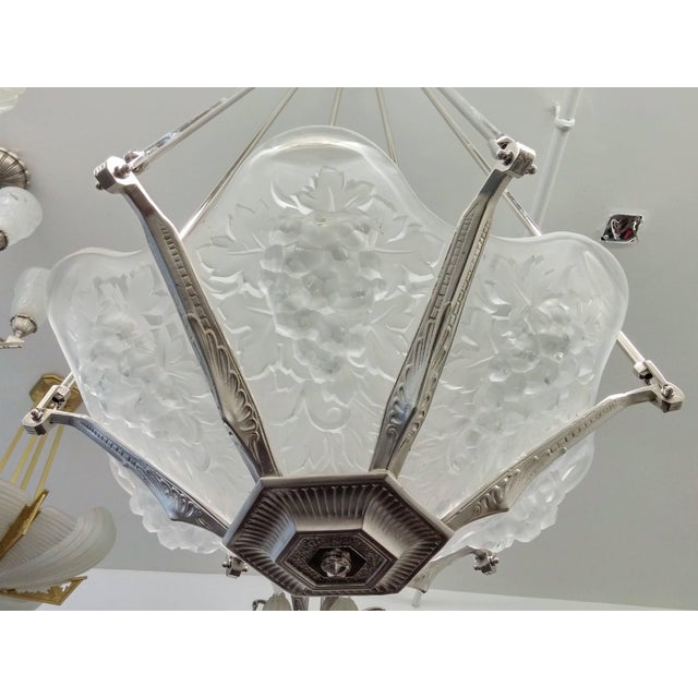 Elegant French Art Deco chandelier created by the French artist "Marius Ernest Sabino" In a bronze geometric design body...