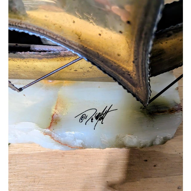 This mid-century pieces feature "torch-cut" brass, copper, or bronze metal, giving the sails and hull a highly textured,...