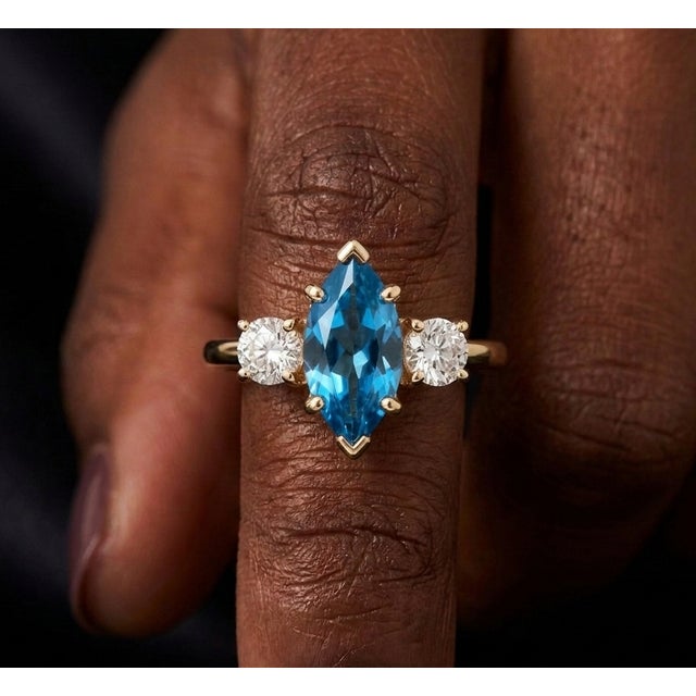 Elevate your jewelry collection with this elegant Swiss Blue Topaz Ring, featuring a vibrant marquise-cut gemstone that...