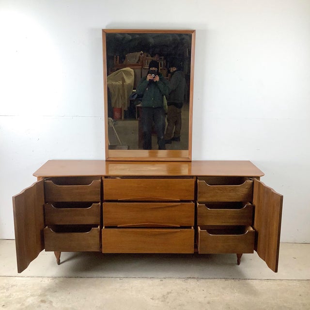 This vintage Mid-Century Modern dresser presents a refined interpretation of mid-20th-century design, defined by its...