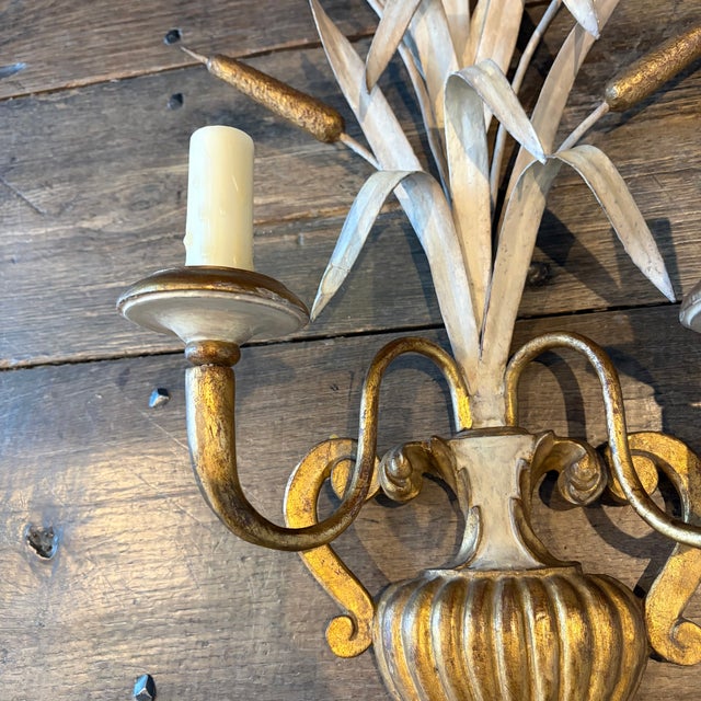 A striking and highly decorative pair of antique French wall sconces, exquisitely crafted in gilt metal and modeled in the...