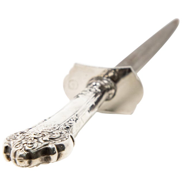 Offering this sterling silver knife sharpener. Having a sterling handle with scrollwork and foliate detail. Hallmarked on...