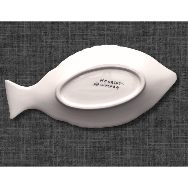 A pair of Henriot Quimper fish-shaped serving dishes hand-painted by celebrated artist Guy Trévoux. Finished in the...