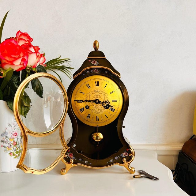 Comtesse mantel bracket shelf clock with pendulum and hand-painted flowers. This beautiful clock in olive green color with...