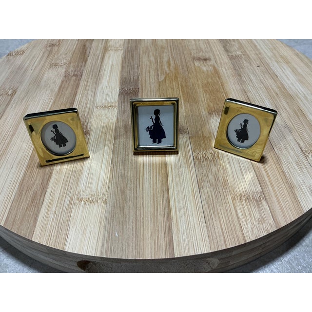 A charming set of three vintage miniature tabletop picture frames crafted in shiny, polished brass. The collection...
