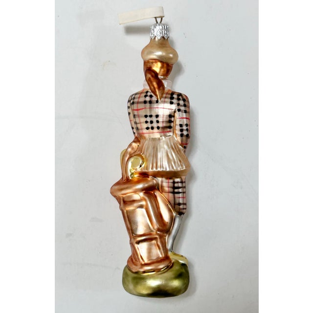 Vintage Polish glass Christmas ornament featuring a female golfer dressed in a traditional plaid golfing outfit,...