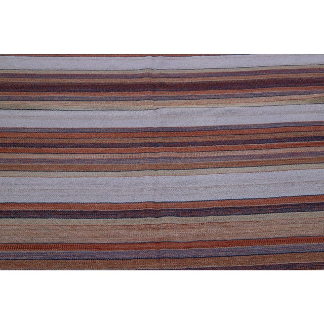 Beautiful Modern Kilim hand-knotted wool rug with multicolor accents in an all-over geometric stripe design. This rug...